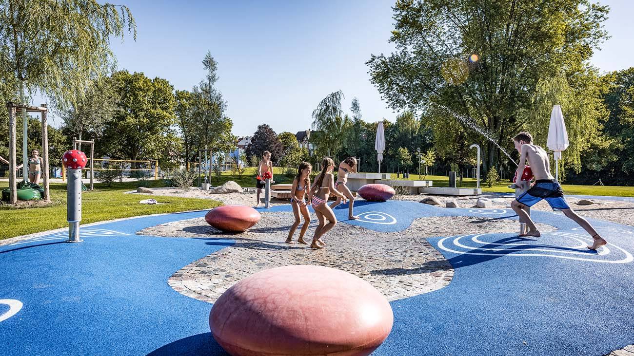 Kinder spielen Matschspielplatz des Freibads Offenburg